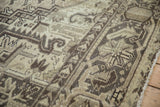 Distressed Mehrivan rug detail, time-softened geometric patterns in beige, charcoal, and pale olive.