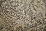 Distressed Mehrivan rug texture detail: geometric stepped pattern in beige and brown.
