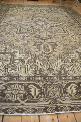 Distressed Mehrivan rug with geometric patterns and worn texture in beige and brown.