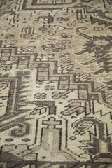 Distressed vintage Mehrivan rug pile, highlighting geometric motifs in beige and chocolate brown.