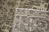 Hand-knotted foundation and secured edge of the vintage Mehrivan rug, showing distressed beige and charcoal.
