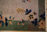 Antique Chinese Art Deco rug corner: gold, terracotta blossoms, navy leaves, green border, worn pile.