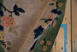 Art Deco rug close-up: hand-knotted pile, navy branches, terracotta flowers, faint foundation.