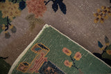 Close-up of Antique Chinese Art Deco rug's green hand-knotted foundation and worn floral pile.