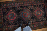 Mehriban rug's raspberry, sky blue, copper geometric medallion, dark navy field, showing foundation.