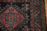 Detail of antique Mehriban rug's raspberry geometric medallion and border, showing foundation wear.