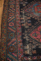 Tattered side and geometric border of an antique Mehriban rug with visible foundation wear.