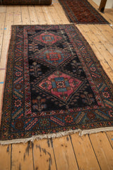 Antique Mehriban rug corner showing serrated floral border, tattered fringe, and worn pile.