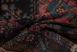 Fringe and geometric floral patterns on an antique Mehriban rug in raspberry, navy, copper.
