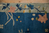 Cobalt blue field with dusty blush lotus and celadon border of an antique Art Deco rug.