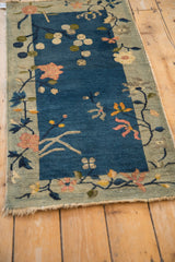 Antique Art Deco runner corner: cobalt blue field, celadon border, pink lotus motifs, and aged fringe.