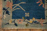 Art Deco rug corner displaying time-softened pile, floral patterns, and natural fringe.