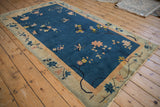 Art Deco border detail of floral branches, lotus flowers, and butterflies in cobalt blue, dusty blush, and gold.