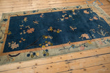 Antique Chinese Art Deco rug corner with cobalt blue field, blush florals, butterfly, and pale green border.