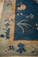 Chinese Art Deco rug featuring cobalt blue field, saffron stripe, and pale lotus motifs.
