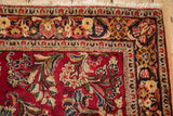 Vintage Sarouk rug corner showing the intricate floral border and bloomed ivory fringe.