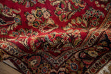 Soft, plush pile of a vintage hand-knotted Sarouk rug showing cherry red floral details.