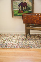 Ivory Kerman rug with flowing blue and pink European floral motifs at the edge.