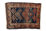 Antique Caucasian rug with lightning serrated medallions, human figures; navy blue, madder red, jade green.