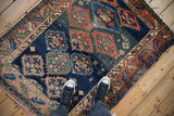 Antique Caucasian rug: lightning serrated medallions on abrashed navy field, featuring madder red.