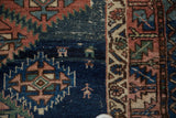 Antique Caucasian rug detail with human figure, lightning serrated navy, red, and ivory patterns.