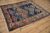 Intricate geometric borders and serrated medallion fragment of the antique Caucasian rug. Navy, terracotta, ivory tones.