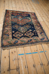 Antique Caucasian rug with lightning serrated medallions, human figures on a navy field.