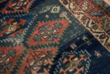 Antique Caucasian rug pile revealing serrated terracotta medallions and blue field with visible knot heads.