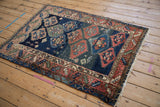 Intact blue selvage and aged ivory fringe on the geometric border of the antique Caucasian rug.