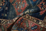 Detail of antique Caucasian rug: serrated geometric motifs, vibrant abrash, and textured pile.