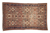 Antique Malayer rug with an allover floral pattern on an ivory field, framed by a navy blue border.