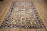 A full perspective of the antique Malayer rug's intricate floral field and dark navy border.
