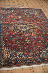 Angled view of an antique Malayer rug, highlighting the Serapi-inspired stepped medallion on a ruby red field.