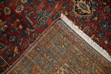 Fine hand-knotted construction and dense red pile of an antique Malayer rug corner.