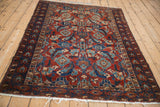 Angled view of a fine antique Malayer rug showing its large-scale Herati pattern in ruby and sapphire tones.