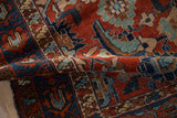 A folded view of the antique Malayer rug highlighting the low pile and gem-like red and blue tones.