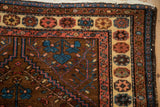Corner detail of the pomegranate motif border on a vintage Kurdish Hamadan wool rug.