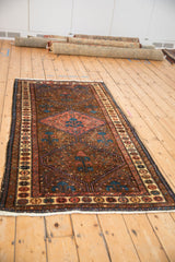 Angled view of a vintage Hamadan rug, showing the tree of life motifs within its triple medallion.