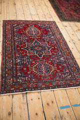 An environmental view of a vintage Karaja rug featuring its cherry red field and sapphire blue medallions.