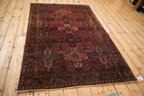 Antique Sarouk rug corner, with raspberry red, dark navy, and dusty gold floral border.