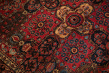 Antique Sarouk rug detail: inverted raspberry red and sky blue floral sprays, dark navy field.