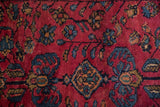 Sprawling blue vines and a diamond medallion on the raspberry red pile of a vintage Lilihan rug.