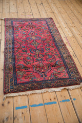 Angled view of a vintage Lilihan rug highlighting its full length, raspberry red field, and intricate floral pattern.
