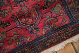 Vintage Lilihan rug corner showing the even pile, raspberry field, and sapphire blue border.
