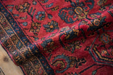 Soft hand-knotted pile of a vintage Lilihan rug showing its raspberry red field and sapphire blue vines.
