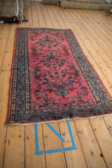 Meandering vine border in denim blue and raspberry floral motifs on a vintage Lilihan rug.
