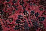 Lustrous magenta pile of a vintage Lilihan rug, showing high-low texture and blue floral stems.