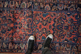 Close-up of the high and low pile texture on a vintage Lilihan rug with navy floral blossoms.