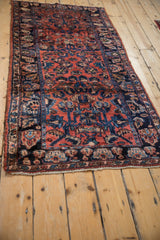 Angled view of a vintage Lilihan runner showing the texture of its dusty rose and navy floral pattern.