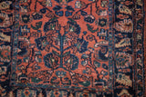 Varied pile height showing hand-knotted floral details in sapphire blue on a dusty rose field.